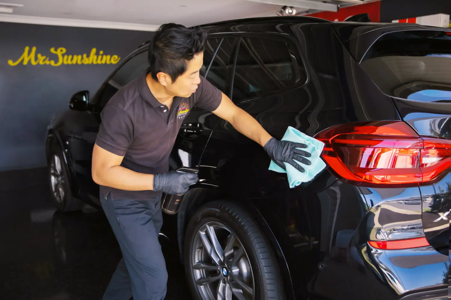 Jason Kim wiping a car | Featured image for the Sumner Car Detailing page