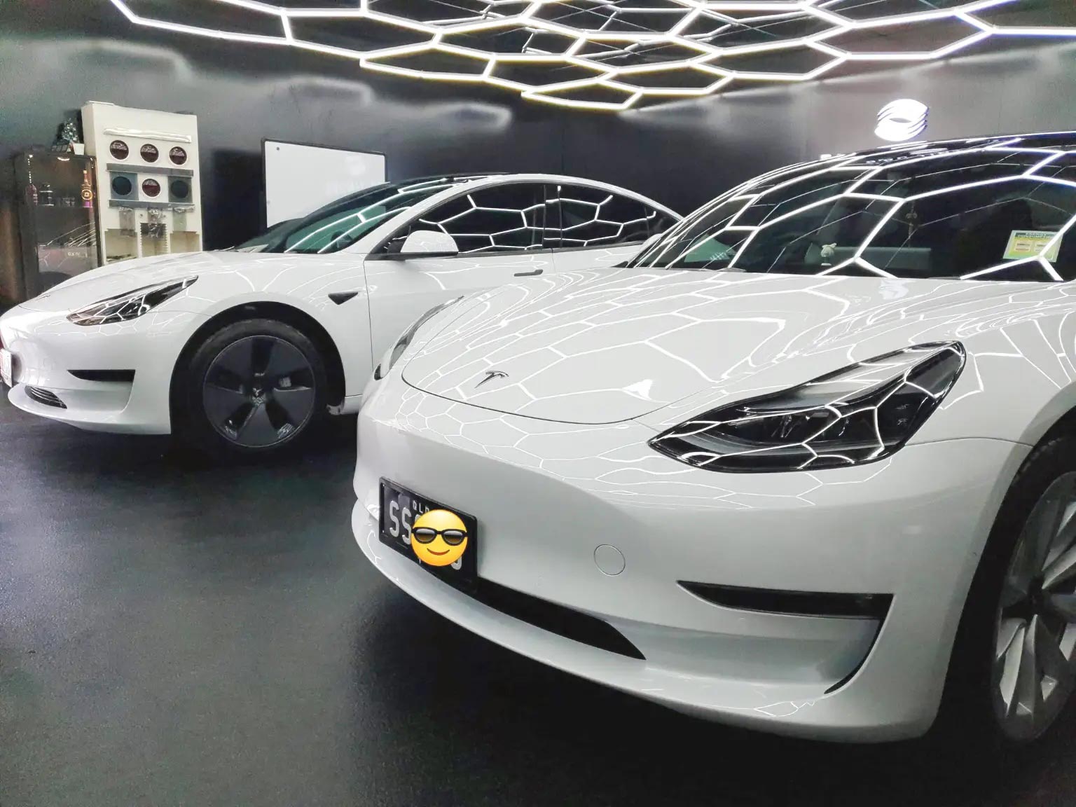 Two white electric cars parked side by side.